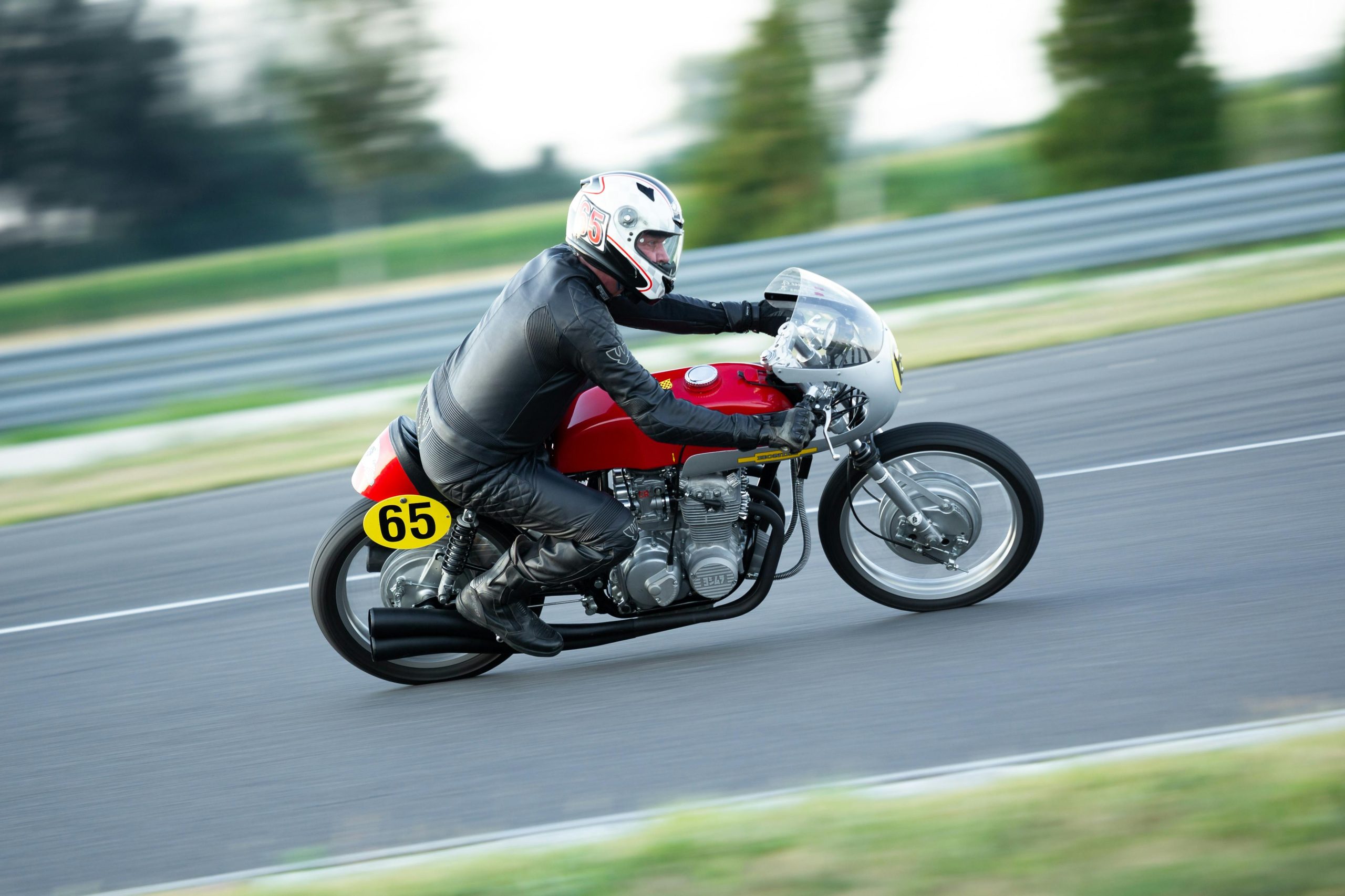 A motorcyclist speeds on a vintage bike during a race, showcasing speed and motion.